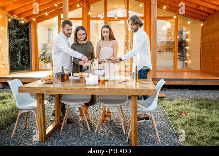 Amici avente uno spuntino sul cortile della casa Foto Stock