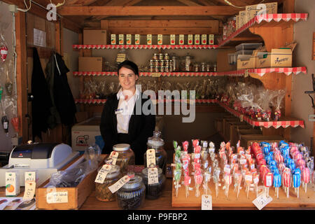 Una ragazza di vendita presso il negozio di caramelle all'aperto presso il museo della città di Den Gamle da ad Aarhus in Danimarca Foto Stock