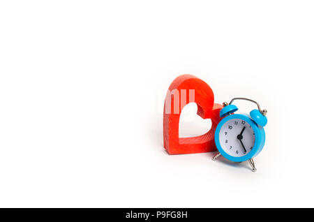Blue sveglia e cuore rosso su sfondo bianco. Il concetto di tempo e di pianificazione. Minimalismo. La speranza di vita. Servizi di intimo. Durata del th Foto Stock