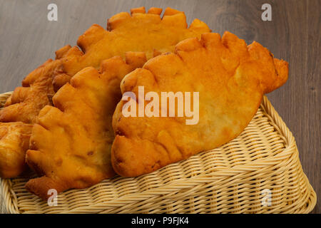 Chebureks fatta in casa, crosta croccante, sfondo legno. Foto Stock