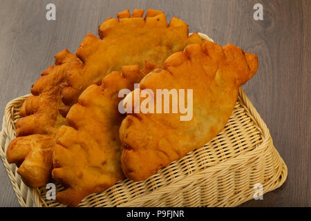 Chebureks fatta in casa, crosta croccante, sfondo legno. Foto Stock