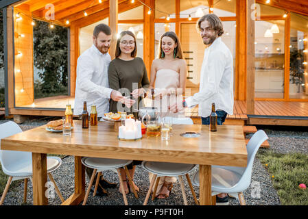 Amici avente uno spuntino sul cortile della casa Foto Stock