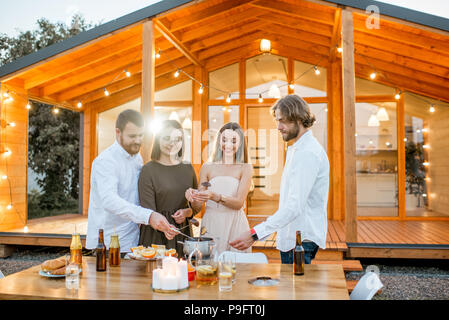 Amici avente uno spuntino sul cortile della casa Foto Stock