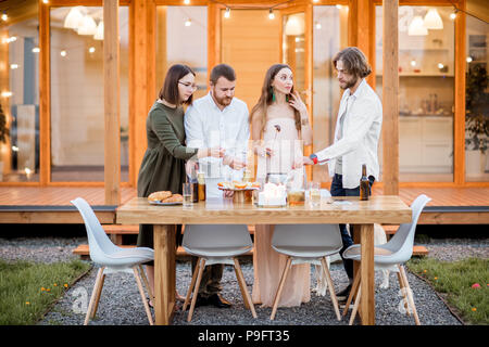 Amici avente uno spuntino sul cortile della casa Foto Stock