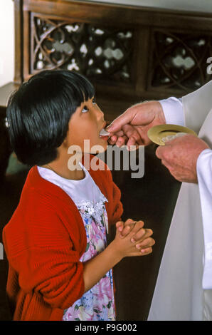 Giovane ragazza asiatica riceve la comunione nella Chiesa cattolica signor © Myrleen Pearson ........Ferguson Cate Foto Stock