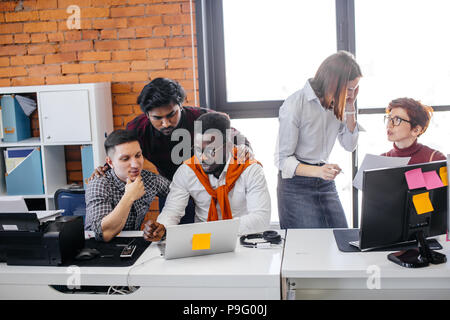 Indian uomo e donna caucasici sono incoraggianti a colleghi di lavoro efficace nel sottotetto interno Foto Stock