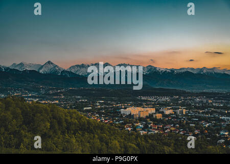 Il tramonto sulla città di Almaty e una vista del tobe Kok torre della TV Foto Stock