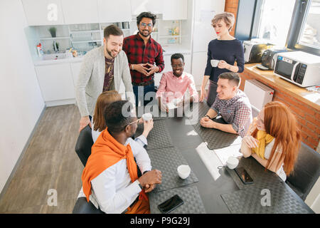 I membri dello staff con diverse nazionalità sono sempre insieme nella sala da pranzo Foto Stock