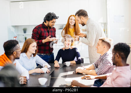 Tide sorridente cheif femmina con gli occhi chiusi è in ascolto i suoi operai si lamenta. I dipendenti sono a convincere il loro leader in pausa Foto Stock