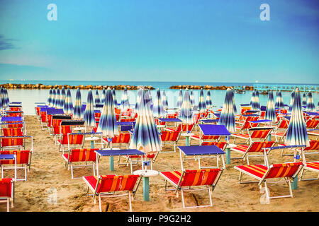 Ombrelloni e sedie a sdraio di località balneari in Emilia Romagna in Italia Foto Stock