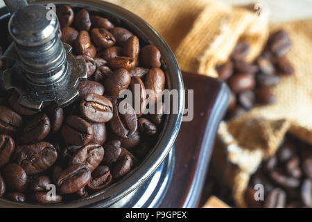 Close up i chicchi di caffè in legno vintage-mulino macinatore Foto Stock