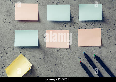 Vuoto colorato sticky notes e matite su uno sfondo a trama. Il concetto di organizzazione e pianificazione. Foto Stock