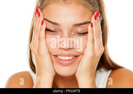 Giovane donna sorridente stringe il viso tra le mani Foto Stock