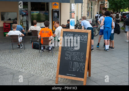 17.06.2018, Berlino, Germania, Europa - i bambini e i giovani sono visibili nella parte anteriore di un negozio nella località di Prenzlauer Berg guardando uno dei fiammiferi. Foto Stock