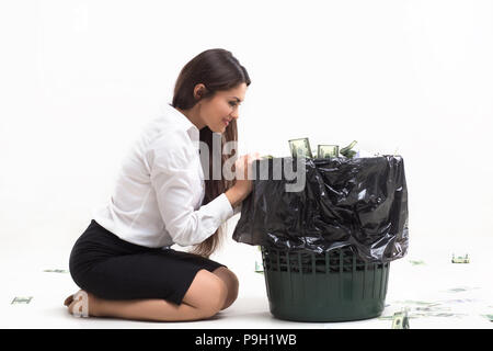 Ragazza seduta accanto al cestino. Foto Stock