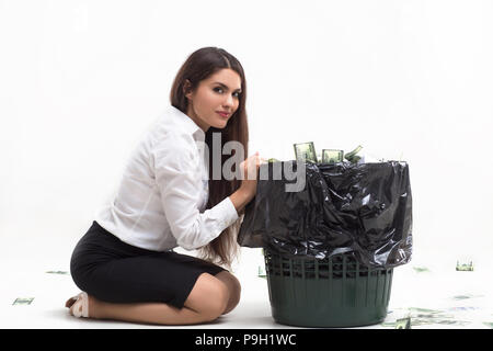 Ragazza seduta accanto al cestino. Foto Stock