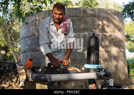 Un agricoltore si accende la pompa della sua nuova irrigazione di gocciolamento sistema che richiede molto meno tempo per l'acqua rispetto al precedente allagare irrigazione. Foto Stock