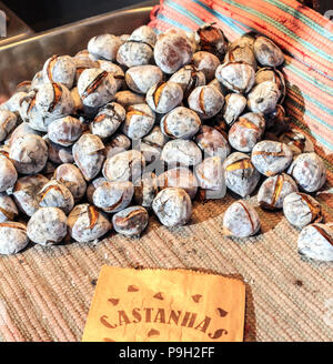 Castagne arrostite coperte di cenere. Castanhas in portoghese Foto Stock
