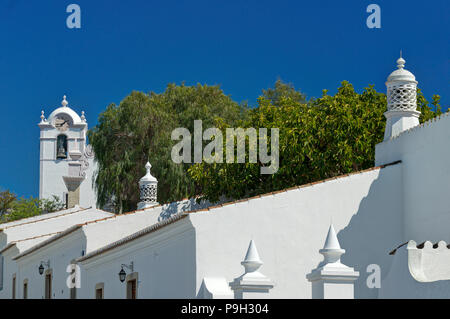 Un ornato di camino e la chiesa di São Lourenço, Almancil, Algarve. Foto Stock