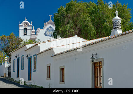 Un ornato di camino e la chiesa di São Lourenço, Almancil, Algarve. Foto Stock