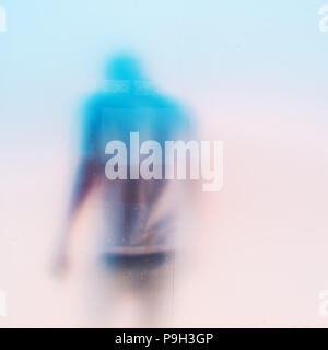 Silhouette di un irriconoscibile triste depresso uomo maschile con la testa verso il basso dietro il vetro sporco finestra Foto Stock