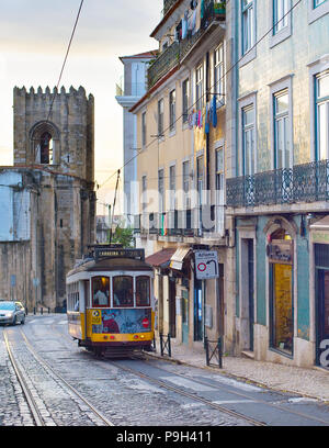 Lisbona, Portogallo - Dic 07, 2016: Tram 28 sulla strada di Alfama. Quartiere Alfama è il centro storico di Lisbona, famosa attrazione turistica. Foto Stock