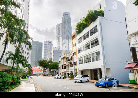 Strada di città di Singapore downtown di automobili parcheggiate nel vago la luce solare Foto Stock