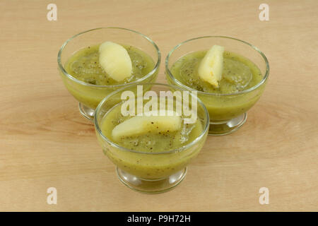Kiwi purea di frutta dolce in bicchieri di vetro con le fette di pere come sano rinfrescante nelle calde estate Foto Stock