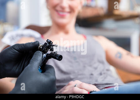 Le mani del tatuaggio artista indossando guanti sterili Foto Stock