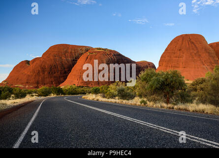 Svuotare strada asfaltata che conduce verso le formazioni rocciose a parte della roccia di Uluru Kata Tjutas. Noto anche come l'Olgas. Outback, Australia Foto Stock