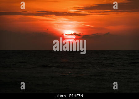 La natura in periodo di crepuscolo, all'alba o al tramonto sul mare con spiaggia sedia. Vista sul mare dalla spiaggia tropicale con cielo viola. Estate spiaggia con mare blu w Foto Stock