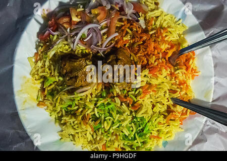 Riso fritto il Nasi goreng con pollo e verdure su una teglia. La tradizione indiana di riso fritto briyani. verde giallo e rosso del riso. Riso multicolore in un Foto Stock