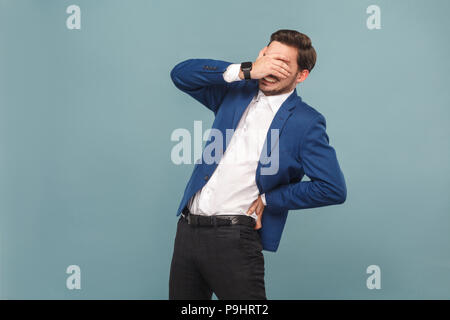 Assistenza sanitaria. Man chiuso gli occhi con disagio nel dorso. ritratto di bello barbuto imprenditore in tuta blu e una camicia bianca, con smart watch. Piscina Foto Stock