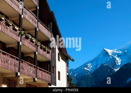 Europea tradizionale alpine ski chalet hotel, vista delle Alpi in distanza. Copia dello spazio nel cielo blu. Foto Stock