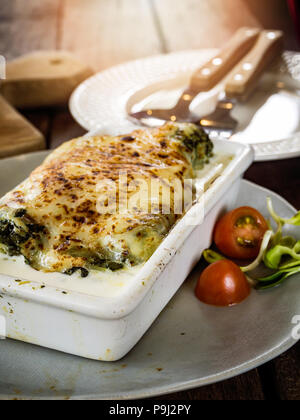 Lasagne in ceramica casseruola servita con pomodoro e basilico, cibo italiano Foto Stock