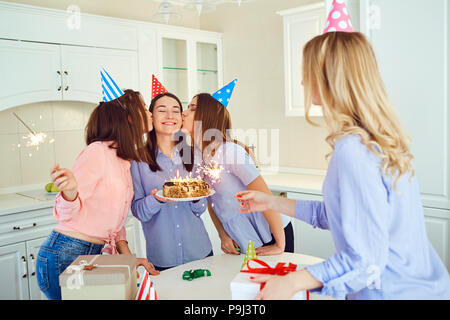 Un gruppo di amiche con una torta con candele di celebrare un birt Foto Stock