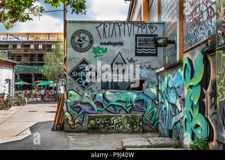 Berlin Friedrichshain, materie Gelände. Colorato coperto di graffiti pubblicizza la parete Cassiopeia nightclub, Skatehalle & Der Kegel (cono) Foto Stock