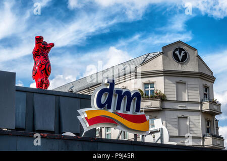 Berlin Friedrichshain, Rosso Berlino Buddy bear, DM farmacia logo ed edifici di appartamenti Foto Stock