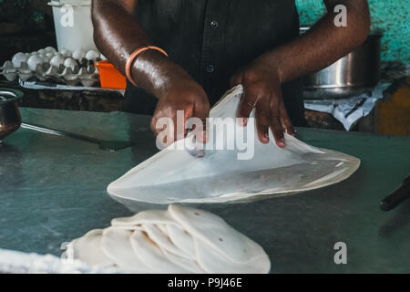 Produrre un impasto di pane. Chef indiano prepara un grande torta. cucina di strada in India. fare frittelle. Foto Stock