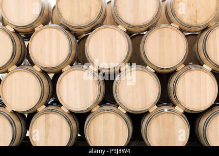 Botti da vino impilati nella vecchia cantina dell'azienda vinicola Foto Stock