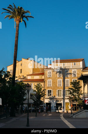 Negozi, ristoranti e palme sulla piazza principale del paese di Antibes, Cote d'Azur, in Francia, una popolare destinazione turistica Foto Stock