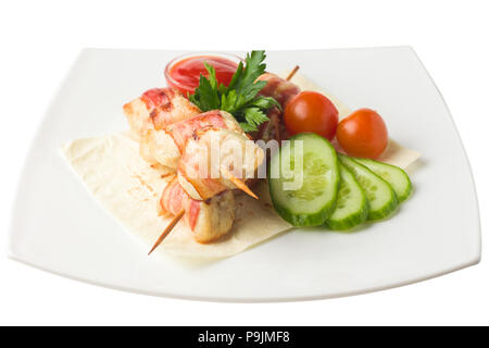 Pollo su uno spiedino, cotta in pancetta, poggia su una pita con cucumb Foto Stock