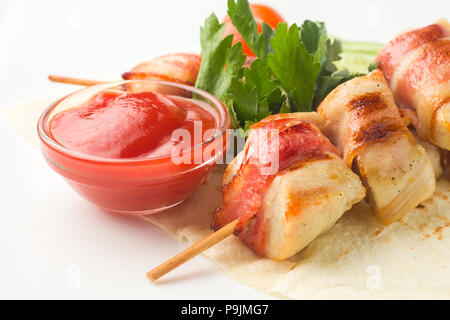 Pollo su uno spiedino, cotta in pancetta, poggia su una pita con cucumb Foto Stock