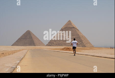 Uomo che corre davanti alle Piramidi di Giza in Egitto Foto Stock