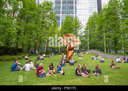 Ufficio i lavoratori aventi la loro pausa pranzo nel Parco del Cinquantenario, Canary Wharf, London, Regno Unito Foto Stock