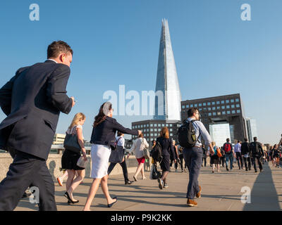 Pendolari attraversando il Ponte di Londra con la Shard in background, London, Regno Unito Foto Stock