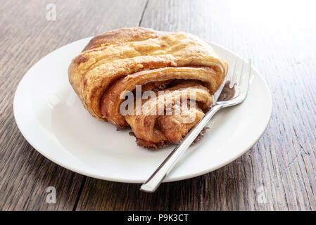 Close-up shot di Franzbroetchen la pasta sulla piastra su tavola in legno rustico Foto Stock
