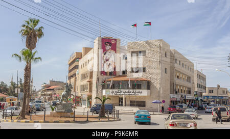 Madaba, GIORDANIA - Aprile 25, 2016: Centro di Madaba in Giordania con il palazzo comunale di Madaba e un banner con il re Abdullah Foto Stock