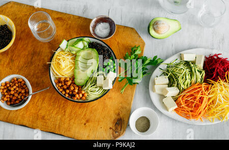 Cibo sano e pulito di mangiare. Ciotola di buddha con spiralizzato verdure bianco sul tavolo di legno, vista dall'alto Foto Stock