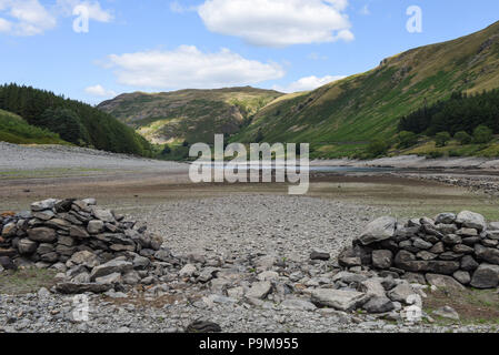 Haweswater, Cumbria Regno Unito. 19 luglio 2018. Una sezione demolita di mura nel villaggio solitamente sommerso di Mardale Green che fu evacuata per far posto al bacino idrico di Haweswater che fu riempito negli anni '1930 per aiutare l'acqua potabile ad essere pompata a Manchester a oltre 80 miglia di distanza. Fig. Ripresa 19/07/2018. Credito: Interrompi stampa Media/Alamy Live News Foto Stock